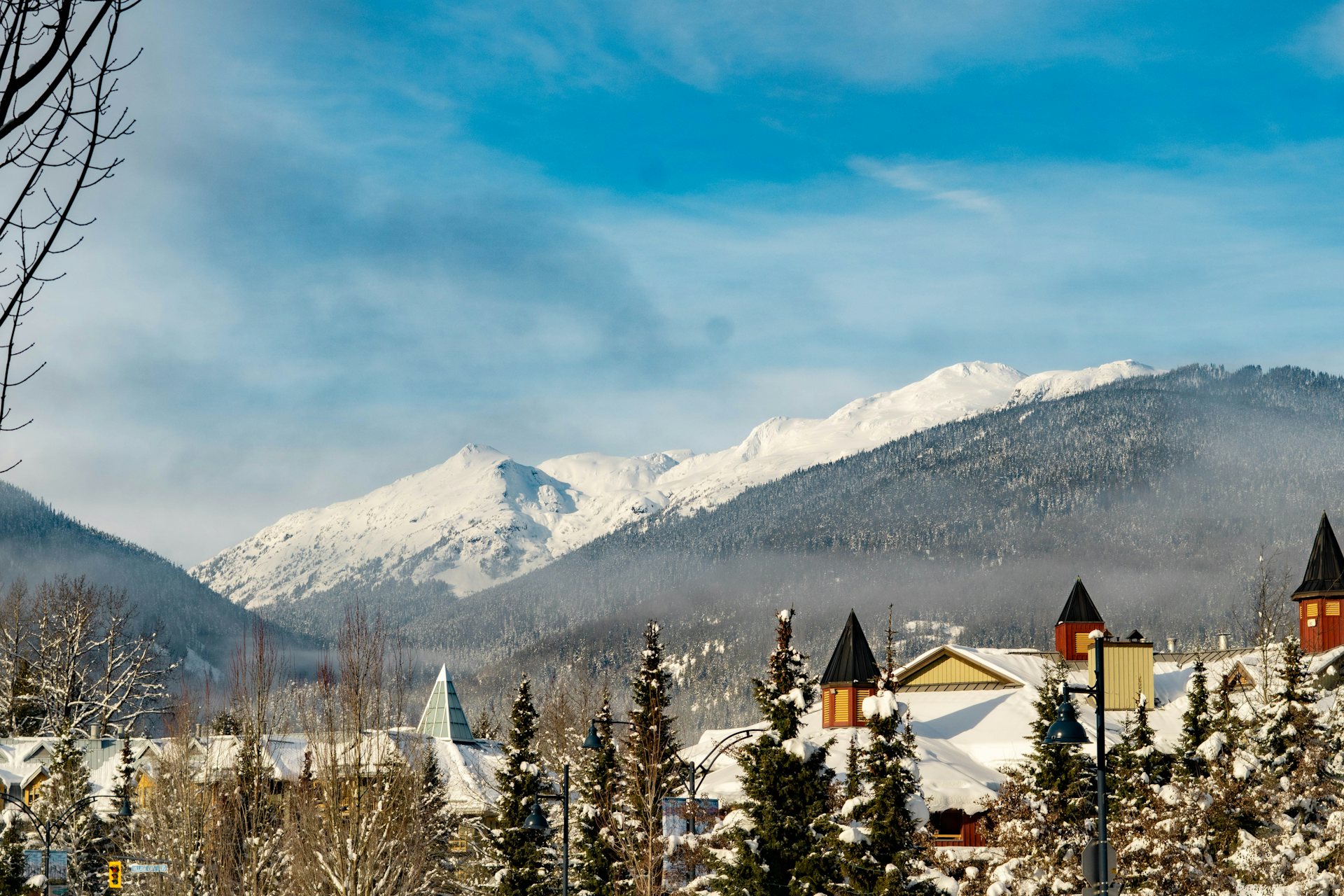 Snow-covered Whistler Village rooftops below the snowy peaks of Whistler Blackcomb